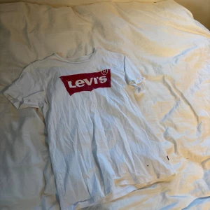 Vit Levi's t-shirt med röd logga - Vit t-shirt från Levi's med klassisk röd logga tryckt på bröstet. 