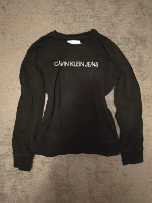 Calvin Klein sweatshirt - En svart Calvin Klein sweatshirt. Säljer då den inte kommer till användning. Använd max 3 gånger.
