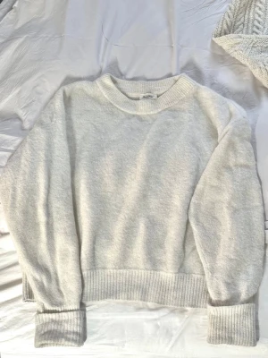 Vit stickad tröja  - Mysig vit, fluffig stickad tröja från American Vintage i storlek XS/S🤍 Tröjan har långa ärmar, ribbade muddar och är tillverkad av högkvalitativt material med en mjuk blandning med alpacka och ull och är därför också ordentligt varm. Passar perfekt nu i vinter ❄️ Ordinarie pris ca. 2000 kr. 