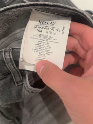 Replay grå jeans straight fit - Säljer ett par grå jeans från Replay med klassisk femficksdesign och snyggt broderad bakficka. Jeansen har rak passform och är tillverkade i mjukt jeanstyg som sitter skönt hela dagen. Perfekt för dig som gillar stilrena och enkla jeans.
