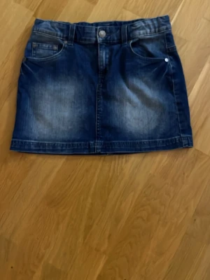 Blå jeanskjol från Benetton Jeans - Säljer en snygg blå jeanskjol från Benetton Jeans.