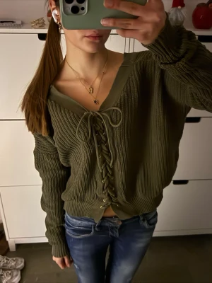 stickad tröja med snörning/knytning - Cool grön stickad tröja med knytning/snörning! Finns ingen lapp så vet inte storlek eller märke ❤️ Uppskattad storlek S!