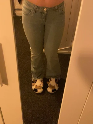 Bootcut jeans i ljusblå denim - Säljer ett par ljusblå bootcut jeans från Wrangler med klassisk femficksdesign och rosa broderi på bakfickorna. Jeansen har låg midja och är gjorda i mjuk denim med dragkedja och knapp framtill. Perfekt passform och snygg siluett. Helt helt nya men säljer då dom inte passar mig som jag vill. Storlek 38 men passar 36 också