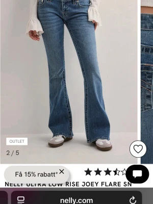 Blå bootcut jeans från Nelly - Snygga blå bootcut jeans från Nelly med låg midja och klassisk femficksdesign. Jeansen har en lätt tvättad look och markerade sömmar, samt utställda ben som ger en retro vibe. Materialet är slitstarkt jeans och passformen är loose vid benen. Färgen på mönstret är ljus rosa.