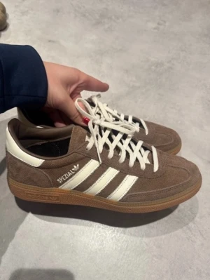 Adidas Spezial bruna sneakers  - Bruna adidas sneakers i modellen ”handball spezial”. Unisex. Storlek: 40 2/3. Använda två gånger och säljes då de inte passa som tänkt. Nyskick och superfina. Osäker på om kartong finns kvar. 