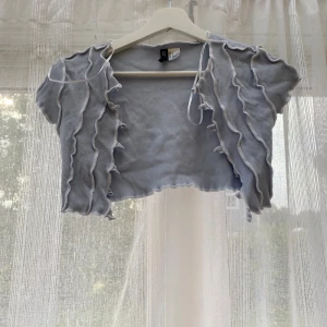 Ljusblå croppad bolerotopp med volanger - De ska vara ett snöre till men den försvann i tvättmaskinen 