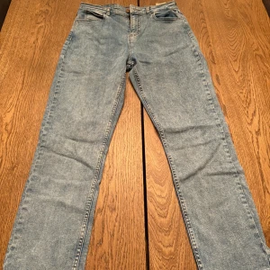 Ljusblå Lee jeans straight fit - Säljer ett par klassiska ljusblå jeans från Lee med raka ben och normal passform. Jeansen har fickor, bälteshällor och Lee-logga på bakfickan. Perfekta till en avslappnad stil och tillverkade i slitstarkt denimtyg. 14-15Y  W29 L30