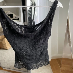 Svart spetslinne från Vero Moda XS - Säljer ett svart, ärmlöst linne från Vero Moda i storlek XS. Toppen är helt i spets med transparent känsla och har en mjuk, rundad halsringning. Perfekt att styla lager på lager eller till ett par jeans.