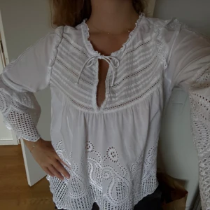 Vit broderad blus - Världen finaste blus med brodyr över hela, knyt fram och vida ärmar efter armbågen. Passar perfekt till sommar och vinter. Lite fransig precis vid knytet pga slitage men syns/märks inte. Köpt second hand på Arkivet i sthlm för 650kr 🤍
