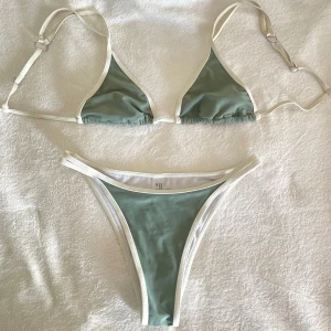 Grön Bikini - Trekantsbikini i grönt med vita kanter. Överdelen har justerbara axelband. Endast testad!