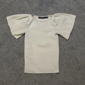 Beige topp - Beige snygg tröja säljer pågrund av att den ej passar längre. Köpt för 350kr. På sida 3 så ser du att det är ett litet hål i nacken på den men går nog att sy igen. Därför säljer billigt. 