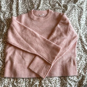 Ljusrosa stickad tröja från Gina Tricot - Supermjuk ljusrosa stickad tröja från Gina Tricot med rund halsringning och breda ribbade muddar vid ärmslut och nederkant. använt en gång innan annars är den helt ny.