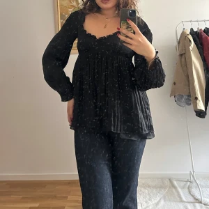 Svart blus från Diane von Furstenberg - Säljer en svart blus från Diane von Furstenberg med volangkant vid halsringningen. Blusen har långärmade, lätt puffade ärmar.