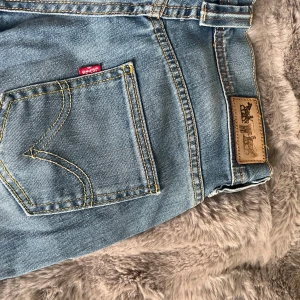 Lågmidjade utsvängda Levis jeans  - Super snygga Levis jeans som är köpta för ca ett år sen, knappt använda. Har sytt upp de själv då de var för långa för mig. W 26 L 34 Inga defekter finns