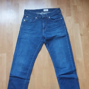 Blå jeansbyxor REX 30/32 Tiger Of Sweden Made in Italy - Snygga blå jeansbyxor från Tiger Of Sweden, tillverkade i Italien. Klassisk femficksmodell med raka ben och normal passform. Materialet är 98% ekologisk bomull och 2%  elastan för lite stretch. Perfekta för dig som gillar stilrena och bekväma jeans. Sparsamt använda så i väldigt fint skick.