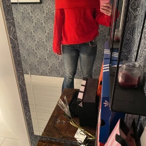 Röd offshoulder stickad tröja - Säljer en snygg röd stickad tröja med offshoulder-design. Tröjan har långa ärmar och en loose passform som ger en avslappnad vibe. Perfekt för dig som vill sticka ut med färg och stil.