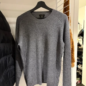Grå stickad tröja massimo dutti  - Säljer en klassisk grå stickad tröja från Morris Stockholm. Tröjan har rund halsringning, ribbade muddar och är långärmad. Perfekt för lager-på-lager och enkel att matcha med jeans eller chinos.