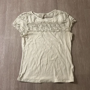 Vit spetsblus från H&M, stl S - Söt vit blus från H&M i storlek S med korta ärmar och detaljerad spets upptill. Blusen har rund halsringning och är tillverkad i mjuk bomull med inslag av spets för en romantisk vibe. Perfekt att styla med jeans eller kjol för en fräsch look. Pris kan diskuteras 🩷