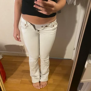 Vita Rock & Republic bootcut jeans - Säljer ett par vita jeans från Rock & Republic med stora svarta RR-loggor på bakfickorna. Byxorna har låg midja och bootcut-ben och klassiska jeansdetaljer. Aldrig sätt någon annan bära denna design och dessa är sååå snygga och unika men tyvärr passar dom mig inte. Kostade drygt 1000 men som ni ser har byxorna lite deffekter (som man säkert kan få bort lätt med lite lust) men har ej försökt då jag ändå inte kan ha dem. Byxorna är i Xxs 