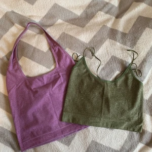 Glittriga toppar från BDG i lila & grön - Två snygga glittriga toppar från BDG, en lila halterneck och en grön med tunna axelband. Båda är croppade och har en lätt skimrande finish som ger extra edge till din outfit. Perfekta att styla med jeans eller kjol för en cool look.
