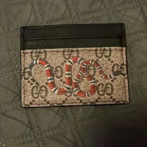 Fin  korthållare - Snygg korthållare från med klassiskt GG-mönster och en cool röd, vit och svart orm på framsidan. Jätte snyggt och missa inte detta 