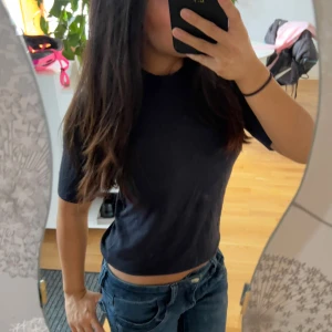 Marinblå stickad t shirt  - Säljer en enkel  marinblå  stickad t-shirt med rund hals och korta ärmar. Toppen är i mjukt bomullsmaterial och har en normal passform som sitter snyggt på kroppen. Perfekt att matcha med jeans eller shorts för en chill look.