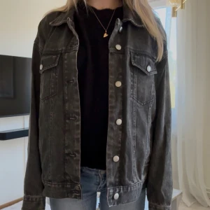 Svart oversized jeansjacka - Säljer en urtvättad svart oversized jeansjacka med klassisk krage och silvriga knappar från Bikbok, perfekt för hösten!!💗Jackan har två bröstfickor med knapp, samt två sidofickor. 