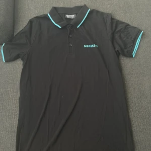 En svart skjorta med blåa märken  - En svart skjorta med blåa mckenzie färg perfekt till fester familje träffar födelsedag och allt annat i storlek S