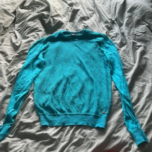 Turkos linnetröja från Hugo Boss - Säljer en turkos långärmad tröja från Hugo Boss i 100% linne. Tröjan har rund halsringning, ribbade muddar och en clean, stilren look. Perfekt för dig som vill ha något lätt och snyggt till våren eller sommaren.