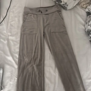 Beiga mjukisbyxor från lager 157 - Supermjuka beiga mjukisbyxor i velour med bred resårmidja och snörning. Byxorna har stora fickor fram och bak, raka ben och en chill loose fit. Perfekta för en avslappnad look eller när du bara vill vara bekväm hemma.