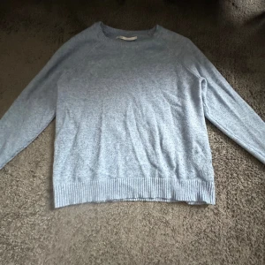 Ljusblå stickad tröja med rund hals - Mysig ljusblå stickad tröja med rund halsringning och långa ärmar. Tröjan har ribbade muddar vid ärmslut. Perfekt till jeans eller kjol. Är storlek S men passar även xs pga Liten i storleken. 