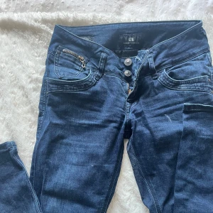 Mörkblå jeans från LTB  - Snygga mörkblå jeans från LTB med cool dragkedjedetalj på fickan och dubbla knappar i midjan. W26 L32