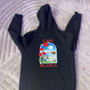 Svart hoodie från Casablanca med tryck - Svart hoodie från Casablanca med färgglatt tryck av rosor och landskap på både bröstet och ryggen. Stor huva och klassisk känguruficka framtill. SAMMA DAG DU KÖPER SAMMA DAG JAG FRAKTAR 