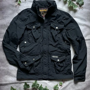 Woolrich Technical Field Jacket – Storlek M - 🎨 Färg: Svart 📏 Storlek: M 📐 Mått: (kan läggas till om du vill att jag hjälper dig mäta) ♻️ Skick: Mycket bra – endast lätt använd, inga skador eller fläckar 🧵 Material: Polyamid / bomull  ‼️ Skickas dagen efter köpet genomförs! ‼️