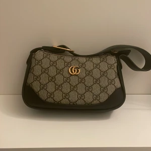 Mönstrad axelväska - Jätte fin väska köpt här på Plick . Men tyvärr bara legat i garderoben. Den är liten men man får plats med telefon osv. 