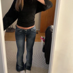 Blå bootcut jeans  - Säljer ett par blå bootcut jeans med låg midja och snygga broderade detaljer på bakfickorna. Jeansen har ljusare slitningar och är tillverkade i stretchigt denim för skön passform. Jenssen kommer tyvärr inte till användning och säljer därför🩷enbart använda 3 gånger🫰🏼
