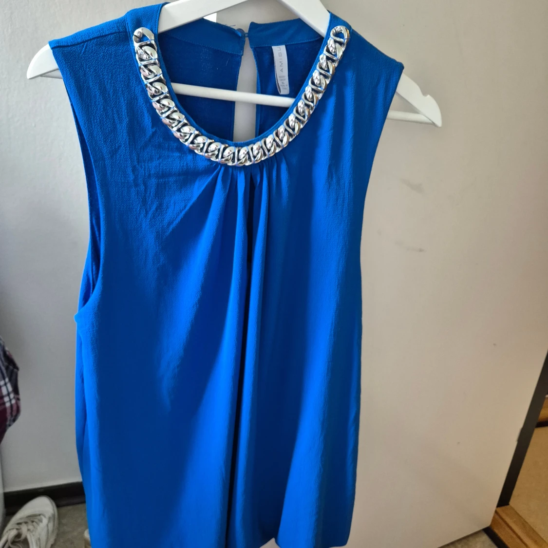 Blå ärmlös blus med silverkedja