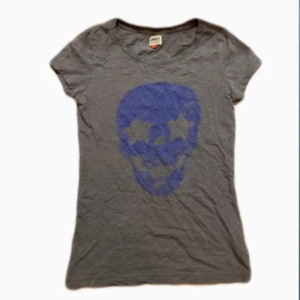 Cool topp  - En jätte cool topp från only! Det är en grå baby tee med en mörkblå dödskalle på!! Tröjan har ett tunt och skönt material och storlek xs-s