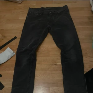 Svarta jeans från Nudie Jeans Co W31 L34 - Svarta jeans från Nudie Jeans Co med klassisk femficksdesign och diskret vågig söm på bakfickan. Jeansen är raka i modellen och tillverkade i slitstarkt bomullstyg. Perfekt för dig som gillar en stilren och enkel look.