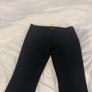 Svarta kostymbyxor från BikBok - Snygga svarta kostymbyxor från BikBok i klassisk rak modell. Byxorna har låg midja. 