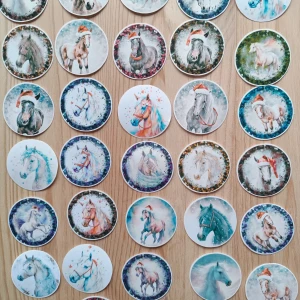 Ej elektronikprodukt - Den uppladdade bilden visar runda klistermärken med hästmotiv, många med julmotiv som tomteluva. Ingen elektronikprodukt syns på bilden.