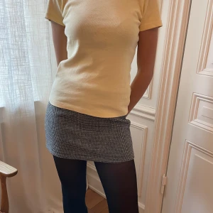 Rutig svartvit minikjol Brandy Melville  - Säljer en snygg kort kjol med klassiskt svartvitt rutmönster. Kjolen har rak passform och är perfekt för dig som gillar en stilren och trendig look. Materialet känns stabilt och passar bra till både stickade tröjor och t-shirts.