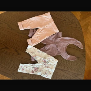 Tre leggings och en dregglis - Två leggings och en dreglis från icas iloveeco, och ett par leggings från Newfie med volanger på rumpan. Storlek 56. Fint skick.