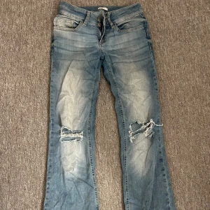 Ljusblå slitna bootcut jeans - Ljusblåa populära jeans från Nelly i storlek 34🥰 lite slitningar längst nere vid benen (se bild 4 och 5) utöver de är dom i väldigt bra skick!