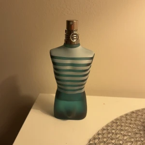 Jean Paul Gaultier Le Male parfym - Ikonisk parfym i cool designad flaska formad som en torso. Levereras med originalförpackning. Perfekt för dig som vill sticka ut och addera en klassiker till din samling.