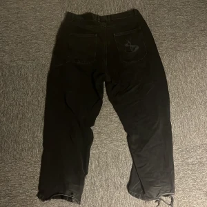 Svarta byxor från Yardsale med broderad ficka - Svarta byxor från Yardsale i storlek L. Byxorna har stora ben och har en baggy passform. 