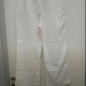 Vita linnebyxor med raka ben - Snygga vita linnebyxor med raka ben och klassisk passform. Byxorna har hällor för bälte och sidfickor, perfekta för en fräsch och stilren look. Lätta och luftiga, passar grymt till varmare dagar.