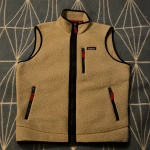 Patagonia väst - Säljer en beige fleeceväst från Patagonia köpt ett år sedan men har sällan blivit Andvänd. Säljes pga av att jag har växt ur den. Västen är helt felfri och i perfekt skick!
