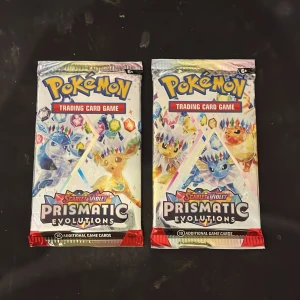 Pokémon Scarlet & Violet Prismatic Evolutions Booster Pack - Två oöppnade booster packs från Pokémon Scarlet & Violet Prismatic Evolutions. Varje paket innehåller 10 samlarkort. Förpackningarna är i nyskick utan synliga skador eller slitage – perfekt för samlare eller spelare.