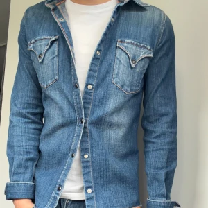 Nudie Jeans skjorta - Hej, säljer nu en helt sjukt snygg jeansskjorta ifrån Nudie Jeans. | Den är i nyskick och omöjlig att köpa ny. | Sitter brutalt snyggt på och har en sjuk tvätt. | Modellen är 180, först till kvarn på denna! | Hör av er vid frågor!🌟